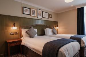 um quarto de hotel com duas camas e uma janela em The Sanctuary House Hotel em Londres