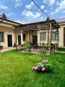 une maison avec une cour ornée de fleurs dans l'herbe dans l'établissement Zahid Inn, à Tachkent