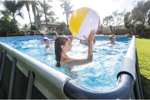 una ragazza che gioca con un pallone da spiaggia in una piscina di La Vougerotte - Terrasse Vue Montagnes a Vougy