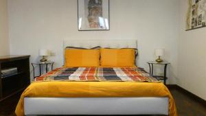 una camera da letto con un letto con cuscini arancioni e 2 lampade di Mamma Mia on ground floor with private parking TV-VENICE a Treviso