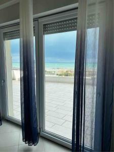 una grande finestra con vista sulla spiaggia di Nautilus Appartamenti a mare a Ortona
