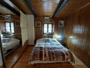 a bedroom with a bed in a room with wooden walls at casa Fiorella in Mattie