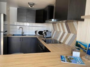 a kitchen with black cabinets and a wooden counter top at Appartement Arès - à 900m du Bassin in Arès