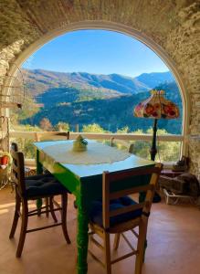 einen Tisch und Stühle in einem Zimmer mit einem großen Fenster in der Unterkunft B&B L' Antica Macina in Quiliano