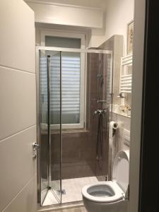 a bathroom with a shower with a toilet and a window at Via Puccini 217 in Viareggio