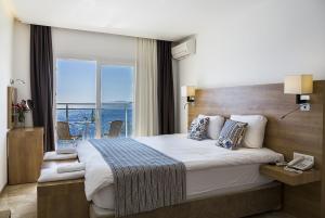um quarto de hotel com uma cama grande e uma janela em Rhapsody Hotel Kas em Kas