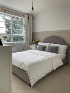 a bedroom with a large white bed with a window at Family home close to Bournemouth town centre in Bournemouth