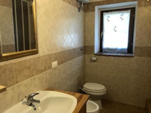 ein Bad mit einem Waschbecken, einem WC und einem Fenster in der Unterkunft La casetta in Ferentillo