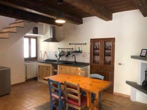 eine Küche mit einem Holztisch und einigen Stühlen in der Unterkunft La casetta in Ferentillo
