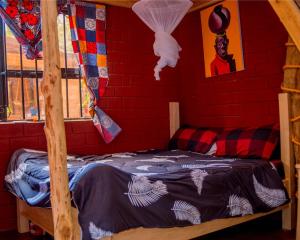 Cama en habitación con pared de ladrillo rojo en Meleji studio room, en Arusha