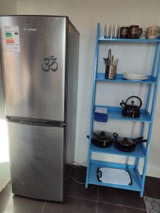 uma cozinha com frigorífico e uma prateleira com panelas em Cabañas Rica-Rica Lodge em San Pedro de Atacama
