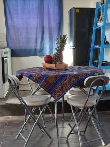 a table with chairs and a pineapple on top of it at Cabañas Rica-Rica Lodge in San Pedro de Atacama
