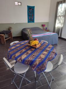 a table with bananas and pineapple on it in a room at Cabañas Rica-Rica Lodge in San Pedro de Atacama