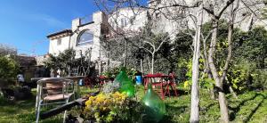 un jardín con mesas y sillas frente a una casa en B&B L' Antica Macina, en Quiliano