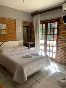 a bedroom with two beds with towels on them at Hotel D'Luz in Itapema