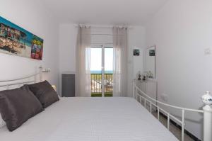 um quarto branco com uma cama e uma janela em 1221 MOLINO 60 m Playa em Roses