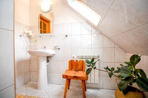 W łazience znajduje się umywalka i drewniane krzesło. w obiekcie Dom u Waki w Zakopanem