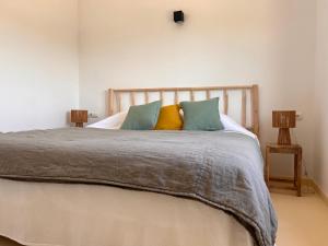 a bedroom with a large bed with colorful pillows at Arenas del Mar Formentera in Es Arenals