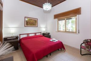 シラクーサにあるVilla Urania by Ortigia Apartmentsのベッドルーム1室(赤いベッド1台、窓付)