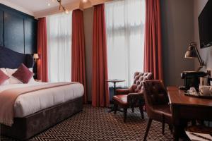 Cette chambre comprend un lit, un bureau et des chaises. dans l'établissement The Sanctuary House Hotel, à Londres