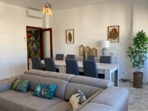 ein Wohnzimmer mit einem Sofa, einem Tisch und Stühlen in der Unterkunft Tropical Apartment in Gallipoli