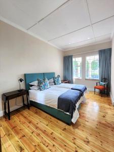 a bedroom with a large bed and a wooden floor at Hydrangea Guest House in Nottingham Road