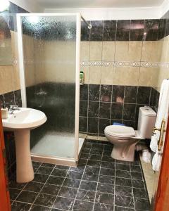 W łazience znajduje się prysznic, toaleta i umywalka. w obiekcie Gold Guest House & Bar w mieście Përmet