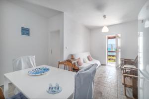 a white dining room with a white table and chairs at Villa Angelos in Nerántza