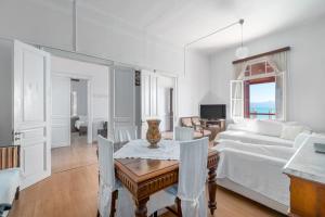 een witte woonkamer met een tafel en een bank bij Villa Angelos in Nerántza