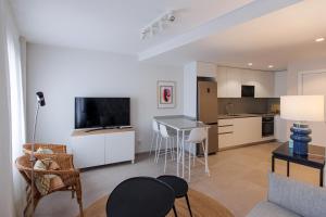 a living room with a table and a kitchen at NEW Stylish 2 Bedroom Apt in Las Palmas de Gran Canaria