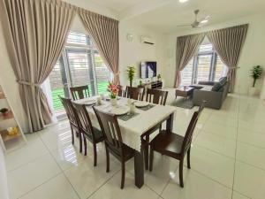 a dining room and living room with a table and chairs at Yarra Park, Up to 10 Pax, 5 Bedrooms, 4 Bathrooms, 2 Car Parks by Star Home in Sungai Petani