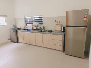 a large kitchen with a stainless steel refrigerator at Yarra Park, Up to 10 Pax, 5 Bedrooms, 4 Bathrooms, 2 Car Parks by Star Home in Sungai Petani
