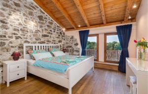 1 dormitorio con cama blanca y pared de piedra en Nice Home In Ruzici With 3 Bedrooms, Wifi And Outdoor Swimming Pool, en Ružići