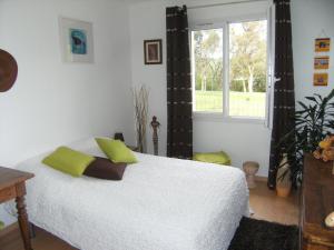 a bedroom with a white bed and a window at La Palibe in Tarnos