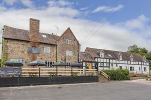a large brick building with umbrellas in front of it at The Hopton Crown in Cleobury Mortimer +15 photos