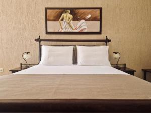 فيلا دانيزيس في ميساريا: غرفة نوم بسرير مع مصباحين وصورة على الحائط