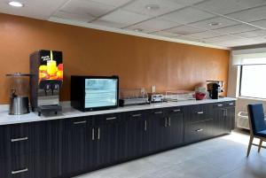 a room with a counter with a tv on it at La Quinta by Wyndham Orlando South in Orlando