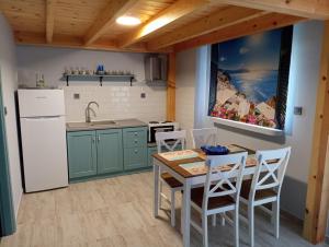 a kitchen with a table and chairs and a refrigerator at Xristos apartment and maisonettes in Sykia Chalkidikis