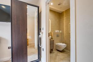 a bathroom with a toilet and a glass door at London Star Hotel in London