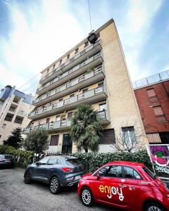 two cars parked in a parking lot in front of a building at 50 Papiniano apartment in Milan