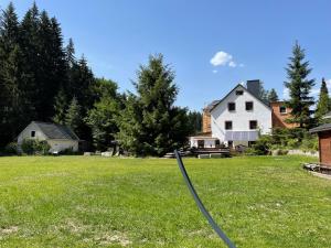 a large yard with a house and a hose at Rauschenbachmühle in Mildenau