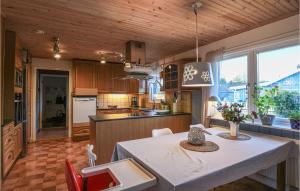 SliteにあるAmazing Home In Slite With 4 Bedrooms And Wifiの白いテーブル付きのキッチンが備わる客室です。
