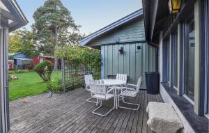 a patio with a table and chairs on a deck at Beautiful Home In Slite With Kitchen in Slite