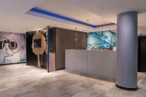 a lobby with a reception desk and paintings on the walls at Park Inn by Radisson, Lagos Victoria Island in Lagos