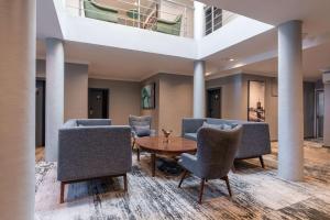 Park Inn by Radisson, Lagos Victoria Island في لاغوس: لوبي فيه كراسي وطاولة وسقف