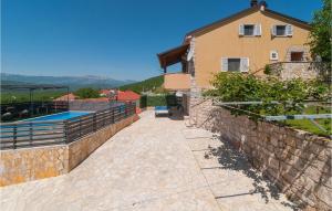 a stone wall next to a house with a swimming pool at Nice Home In Slivno With Outdoor Swimming Pool in Slivno