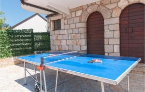 a ping pong table in front of a house at Nice Home In Slivno With Outdoor Swimming Pool in Slivno