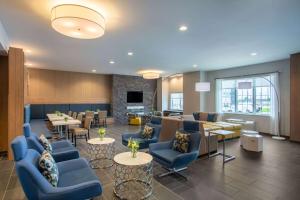 a waiting room with blue chairs and tables at Microtel Inn & Suites by Wyndham Liberty NE Kansas City Area in Liberty