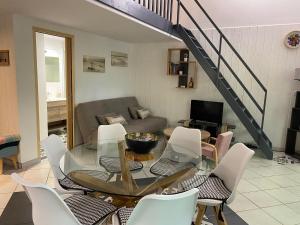 a living room with a glass table and chairs at Appartement Cosy - Les Ecureuils in Arès