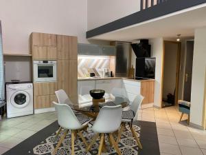 a kitchen with a table and chairs in a kitchen at Appartement Cosy - Les Ecureuils in Arès